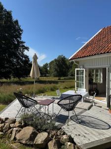 a patio with an umbrella and a table and chairs at Idyllically nice house on Bjärehalvön, Torekov! in Båstad