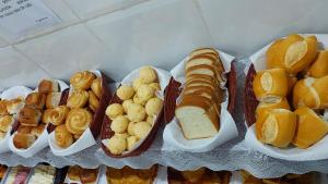 a bunch of different types of bread and pastries at Pousada Ouro Preto in Ouro Preto