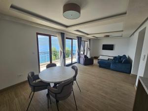 a living room with a table and chairs and a couch at Vile MonteMar in Herceg-Novi
