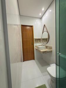 a bathroom with a toilet and a sink and a mirror at Casa da Ladeira in Barreirinhas