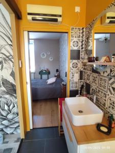 a bathroom with a sink and a bed in a room at Au Jardin de Curé in Auxonne