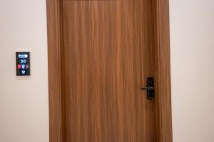 an open wooden door with a remote control on it at الرابية - شقق فارهة - دخـول ذكي in Abha