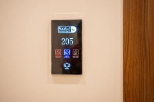 a black remote control on a white wall at الرابية - شقق فارهة - دخـول ذكي in Abha +100 photos