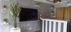 a living room with a flat screen tv on a wall at Dankay City Lodge in Abesem