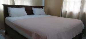 a bedroom with a large bed with white sheets and pillows at Dankay City Lodge in Abesem