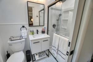 a bathroom with a shower and a toilet and a sink at Catskills Getaway 3BR Retreat with Media Room, Near Casino, Bethel Woods and More in Glen Wild +32 photos