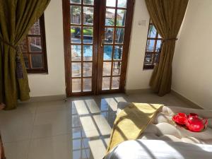 a room with windows and a bed with a table at Mi casa guesthouse in Gaborone