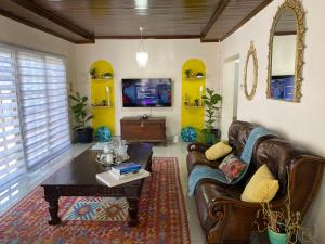 a living room with a leather couch and a coffee table at Mi casa guesthouse in Gaborone