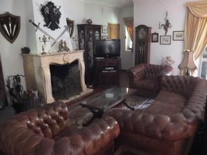 a living room with leather furniture and a fireplace at Vila Candeias, Vilamoura, Algarve, Beach, 10p in Quarteira