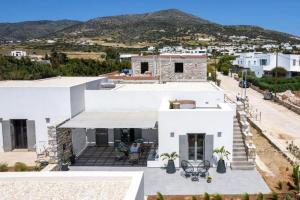 a white house with mountains in the background at Fos Residence Dryos in Drios