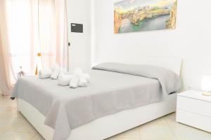 a white bedroom with a bed with white towels at Levante Eight Appartamento Vista Mare in Bari
