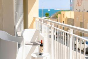 a bottle of wine sitting on a table on a balcony at Levante Eight Appartamento Vista Mare in Bari