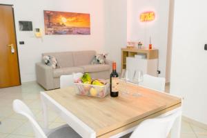 a table with wine glasses and a basket of fruit at Levante Eight Appartamento Vista Mare in Bari