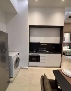 a kitchen with a stove and a washing machine at The Colony By Infinitum in Kuala Lumpur