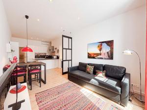 a living room with a black couch and a table at Stalingrad - Wifi, AC, 4pers in Nice