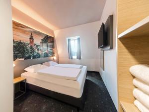 a hotel room with two beds and a flat screen tv at B&B HOTEL Gotha-Hbf in Gotha +17 photos