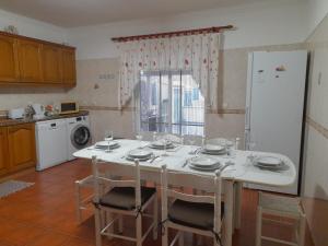a kitchen with a table with chairs and a refrigerator at Marcio's Home in Fernao Ferro