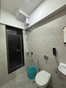 a bathroom with a toilet and a sink at Atithi Homes Luxe Kandivali Suites in Mumbai +40 photos