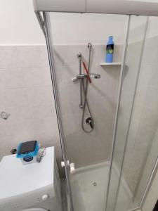 a shower with a glass door next to a toilet at Magnifica in Ostuni
