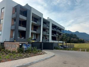 a white apartment building with mountains in the background at 310 The Meadows in George
