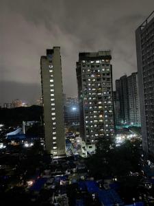 a city skyline with tall buildings at night at Atithi Homes Luxe Kandivali Suites in Mumbai