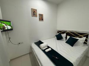 a bedroom with a bed with a tv on the wall at Atithi Homes Luxe Kandivali Suites in Mumbai