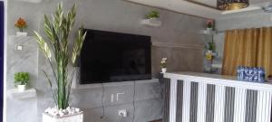 a living room with a flat screen tv on a wall at Dankay City Lodge in Abesem +10 photos