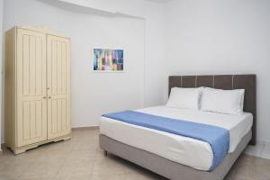 a bedroom with a large bed and a cabinet at Alkara Square in Naxos Chora