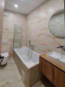 a bathroom with a tub and a sink and a mirror at Hotel Maslina in Seget +81 photos