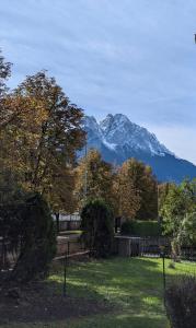 una montaña en la distancia con una valla y árboles en Gemütliche Wohnung in Garmisch nahe Kreuzeck, en Garmisch-Partenkirchen