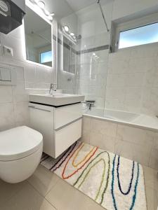 Un baño con inodoro, lavabo y bañera. en Gemütliche Wohnung in Garmisch nahe Kreuzeck, en Garmisch-Partenkirchen