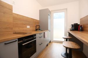 cocina con encimera, fregadero y fogones en Gemütliche Wohnung in Garmisch nahe Kreuzeck, en Garmisch-Partenkirchen 8 fotos más