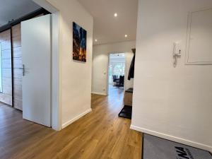 Un pasillo con paredes blancas y suelos de madera. en Gemütliche Wohnung in Garmisch nahe Kreuzeck, en Garmisch-Partenkirchen