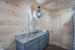 a bathroom with a sink and a mirror at Cozy Cabin near Historic Dahlonega Town Square in Dahlonega +14 photos