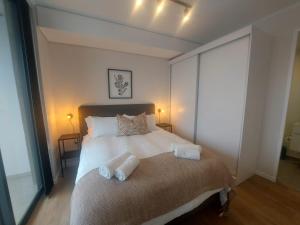 a bedroom with a bed with two towels on it at 210 The Meadows in George +25 photos