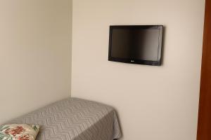 a flat screen tv hanging on a white wall at Apartamento Cantinho da Cop 30 in Ananindeua