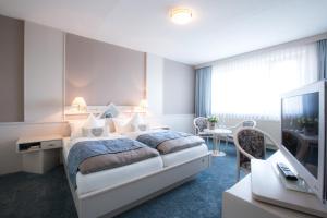 ein Hotelzimmer mit Bett und Fernseher in der Unterkunft Hotel Kristall in Weißwasser