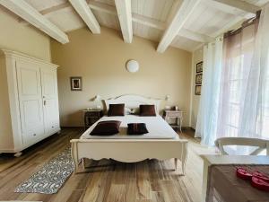 a bedroom with a large white bed in a room at Agriturismo Tenuta Il Molino in Quercianella