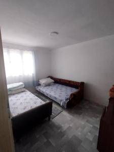 a room with two beds and a couch in it at Kuca Denic in Svrljig
