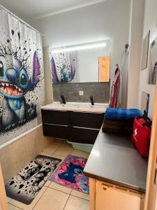 a bathroom with a sink and a mirror at appartement 5min gare RER Disneyland Paris val d'Europe la vallée Village parking inclus in Montévrain