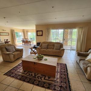 un grand salon avec des canapés et une table basse dans l'établissement Simply Rooted Cottage, à Piet Retief