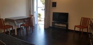 a living room with a table and a television and chairs at Ecoflat Casa Vacanze in Lipari