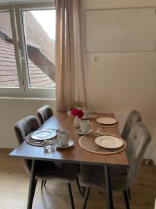 a dining room table with plates and flowers on it at Ferienwohnung Kaltenegger in Gaal