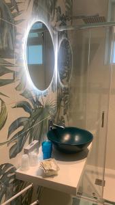 a bathroom with a green sink and a mirror at Appartamento Meriggio in Gabicce Mare