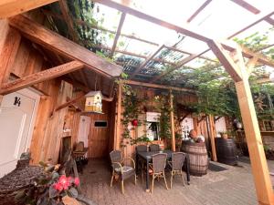 a patio with a table and chairs and a glass roof at Ferienwohnungen am Roland in Neustadt