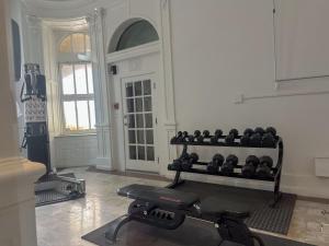 a room with a gym with a bench and weights at Glorestays in Baltimore