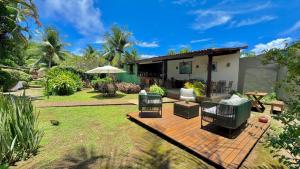 a patio with chairs and an umbrella in a yard at Pousada Cheiro Verde Noronha in Fernando de Noronha