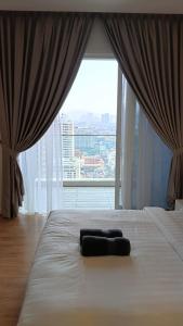 a bed in a room with a large window at Quill Residence- City View Condo by Azmila in Kuala Lumpur