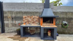 Una casa de juegos con una estufa delante de una pared. en Chalé da Serra, en Santo da Serra