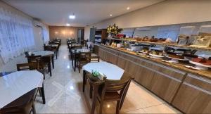 a restaurant with tables and chairs and a counter at Lady Laura Hotel in Taquarituba